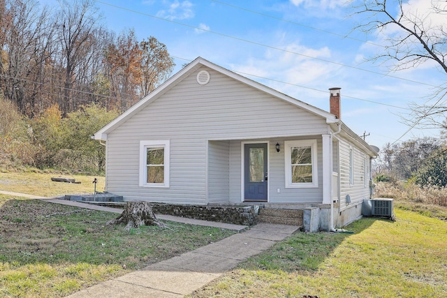 bungalow with central air condition unit and a front lawn