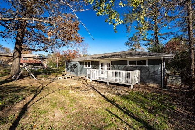 rear view of property with a yard and a deck