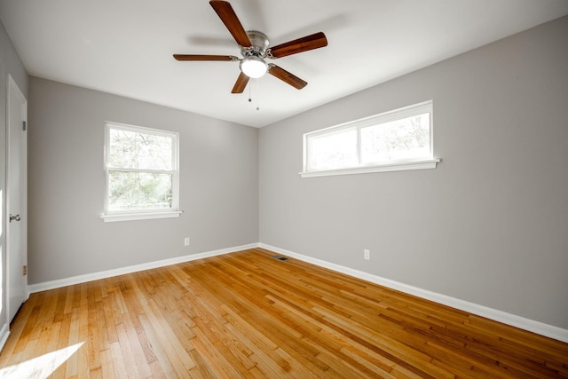 unfurnished room featuring a wealth of natural light, ceiling fan, and light wood-type flooring