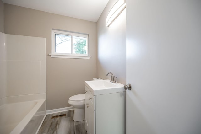 bathroom featuring vanity, wood-type flooring, and toilet