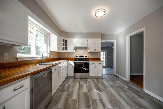 kitchen with sink, white cabinets, wooden counters, and appliances with stainless steel finishes