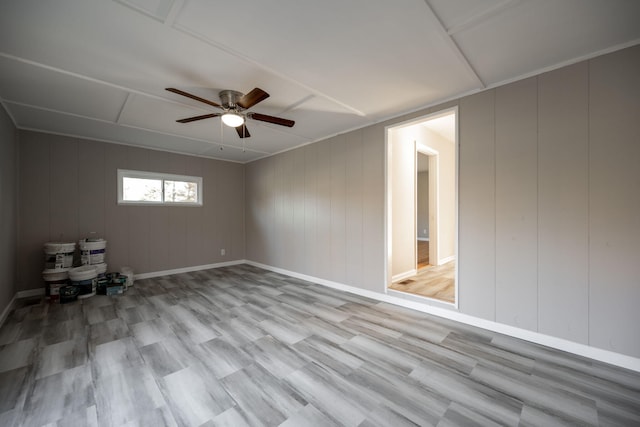 empty room featuring light hardwood / wood-style floors, ceiling fan, and wooden walls