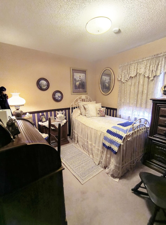 bedroom with carpet floors and a textured ceiling