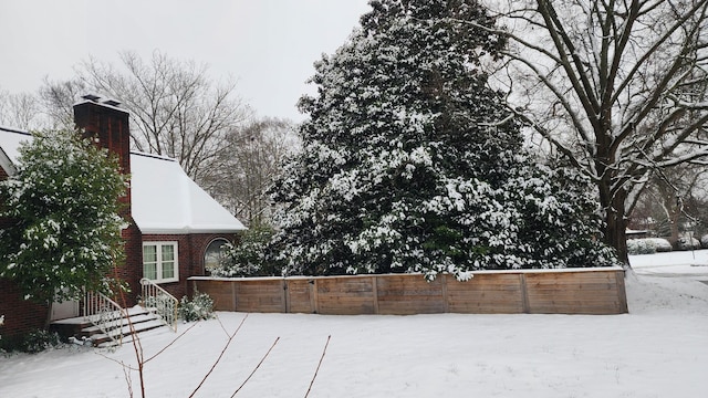 snow covered patio featuring fence