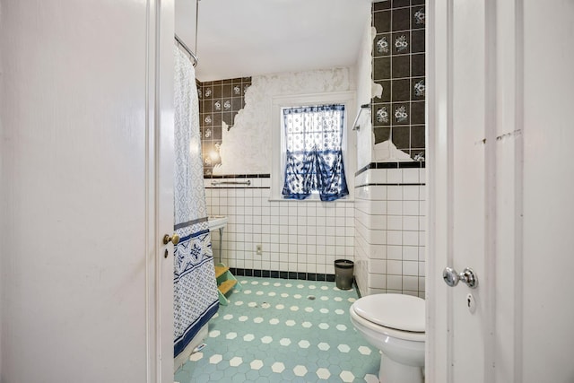 bathroom with toilet and tile walls