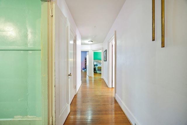 hallway with baseboards and hardwood / wood-style floors