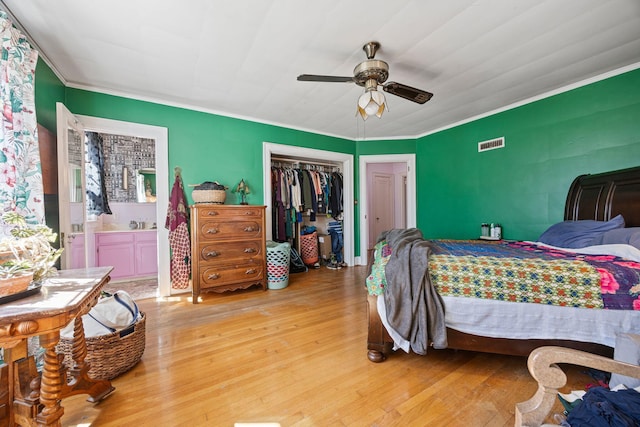 bedroom featuring hardwood / wood-style floors, visible vents, a closet, and ornamental molding