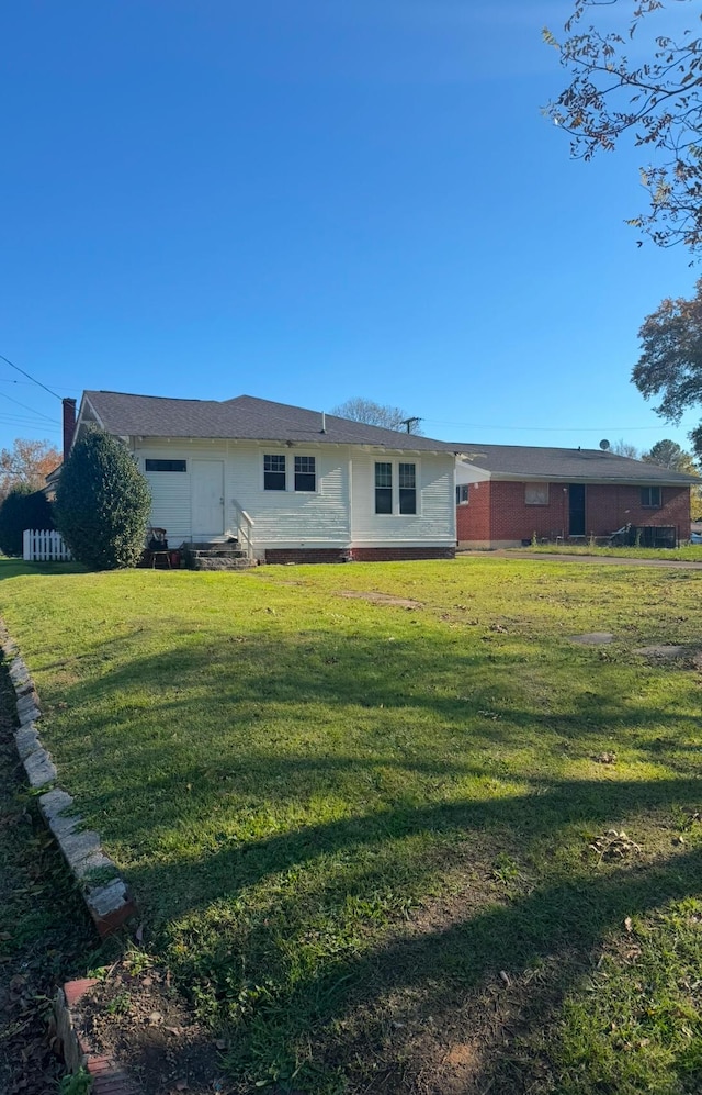 back of property featuring a lawn