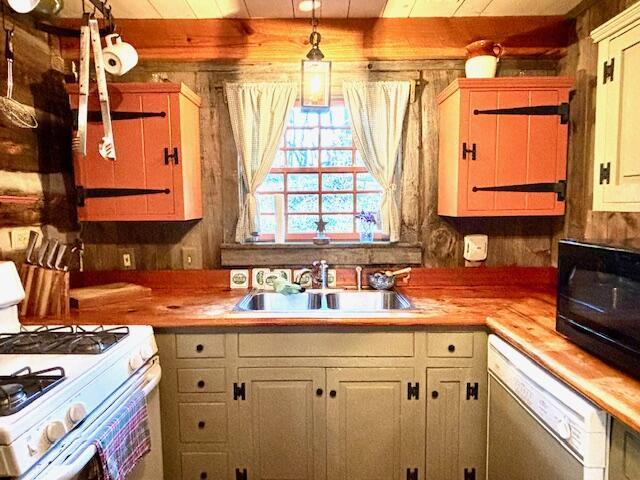 kitchen with hanging light fixtures, sink, wooden counters, and white appliances