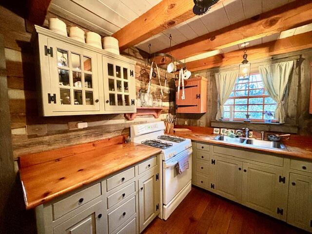 kitchen featuring white cabinetry, hanging light fixtures, gas range gas stove, and sink