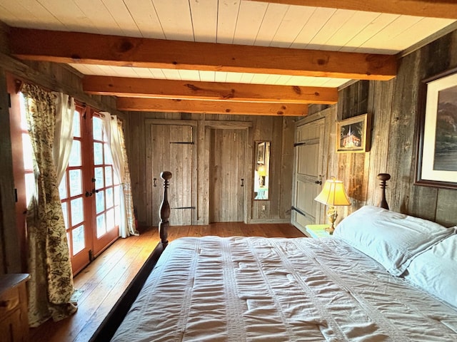 bedroom with wood walls, wooden ceiling, french doors, beamed ceiling, and wood-type flooring