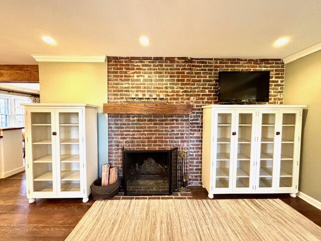 unfurnished living room featuring a fireplace, ornamental molding, and dark wood-type flooring