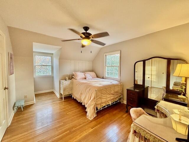 bedroom featuring ceiling fan, hardwood / wood-style floors, and vaulted ceiling