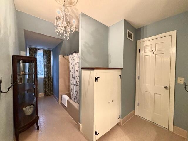 hallway with an inviting chandelier