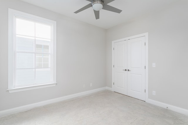 unfurnished bedroom with light carpet, a closet, and ceiling fan