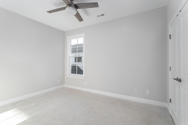 carpeted spare room featuring ceiling fan