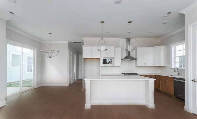 kitchen with wall chimney exhaust hood, a wealth of natural light, dishwasher, and a kitchen island