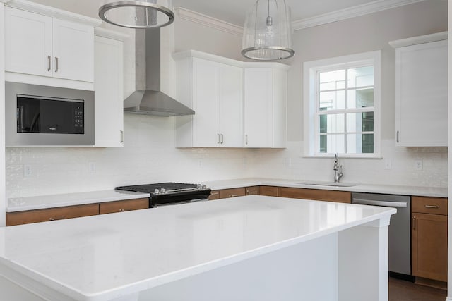 kitchen with wall chimney range hood, black appliances, sink, a center island, and white cabinetry