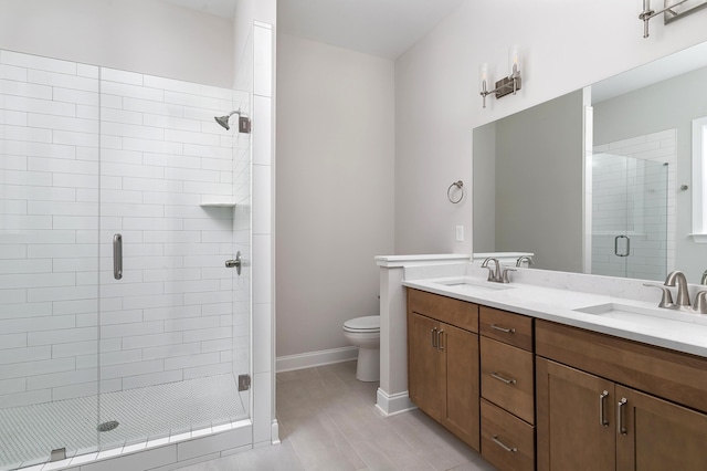 bathroom with vanity, toilet, and a shower with shower door