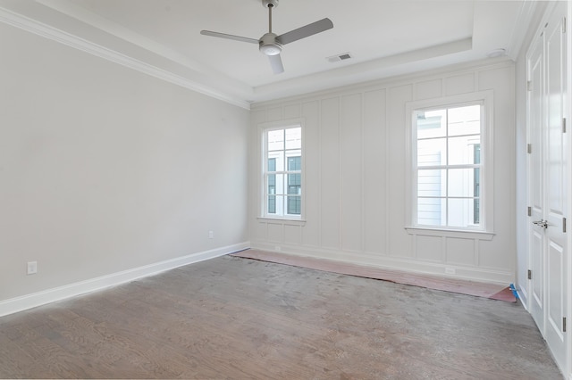 empty room featuring ornamental molding, hardwood / wood-style flooring, ceiling fan, and a tray ceiling