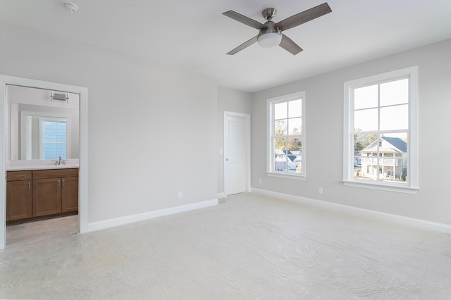 unfurnished room featuring light carpet, ceiling fan, and sink