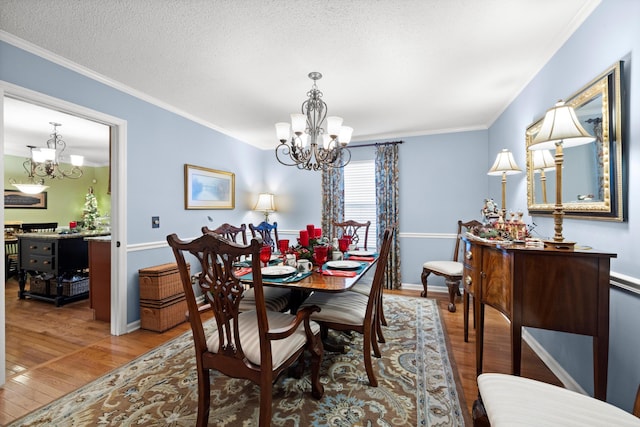 dining area featuring a textured ceiling, hardwood / wood-style flooring, an inviting chandelier, and crown molding