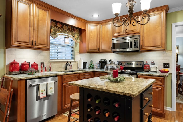 kitchen with sink, a kitchen island, stainless steel appliances, and light wood-type flooring