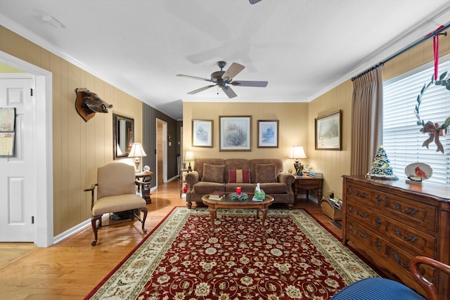 living room featuring light hardwood / wood-style flooring, ceiling fan, and crown molding