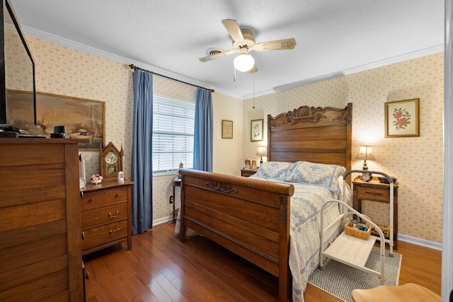 bedroom with a textured ceiling, dark hardwood / wood-style flooring, ceiling fan, and ornamental molding