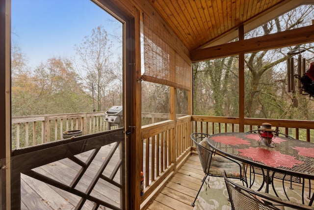 sunroom / solarium with lofted ceiling, wood ceiling, and a wealth of natural light