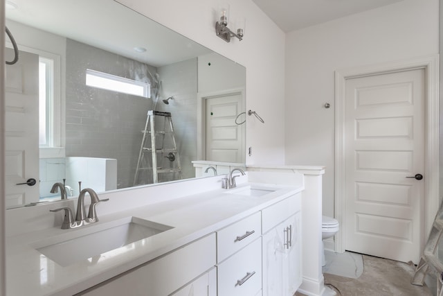 bathroom featuring vanity, toilet, and tiled shower