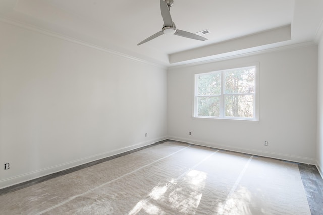 unfurnished room featuring a raised ceiling, ceiling fan, light hardwood / wood-style flooring, and ornamental molding