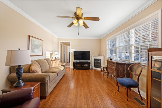 living room featuring hardwood / wood-style floors, ornamental molding, and a wealth of natural light