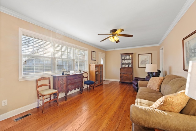 living room with hardwood / wood-style flooring, ceiling fan, and crown molding