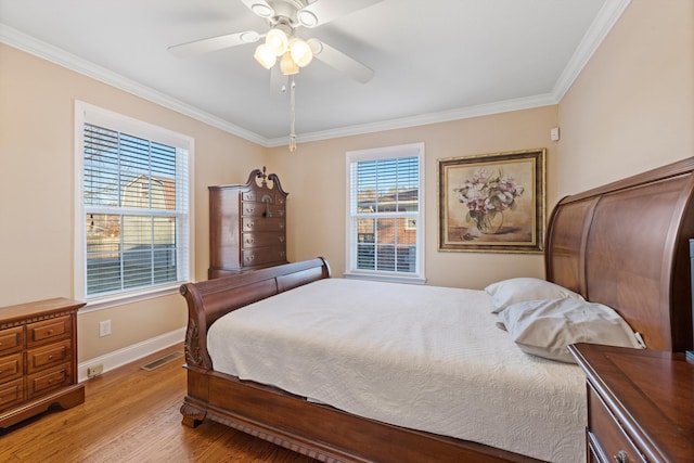 bedroom featuring multiple windows, ceiling fan, crown molding, and light hardwood / wood-style floors