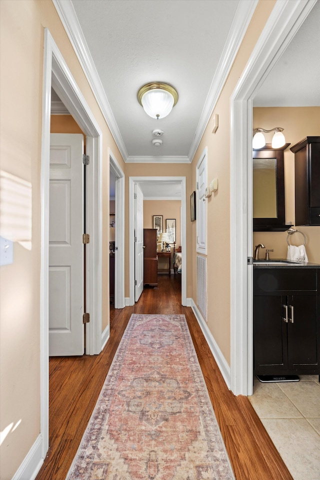 hallway with hardwood / wood-style flooring and ornamental molding