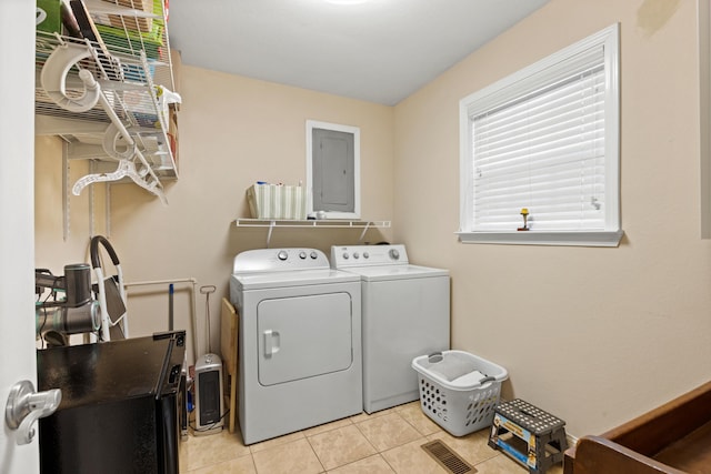 laundry room featuring independent washer and dryer, electric panel, and light tile patterned floors