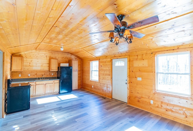 unfurnished living room with lofted ceiling, sink, wooden walls, light hardwood / wood-style flooring, and wood ceiling