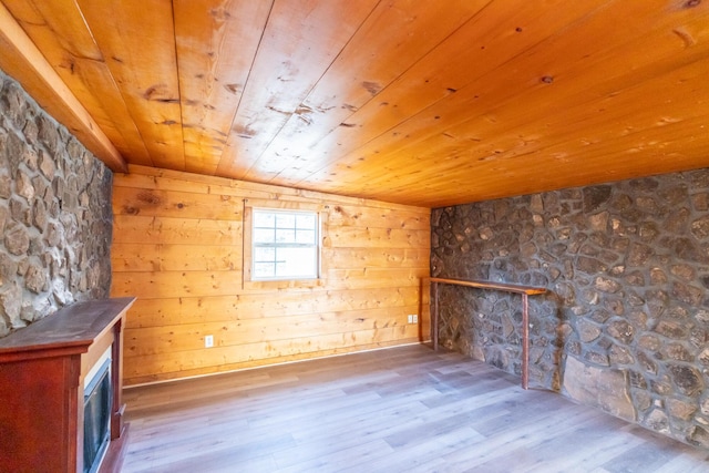 unfurnished living room featuring a fireplace, wood walls, hardwood / wood-style floors, and wood ceiling