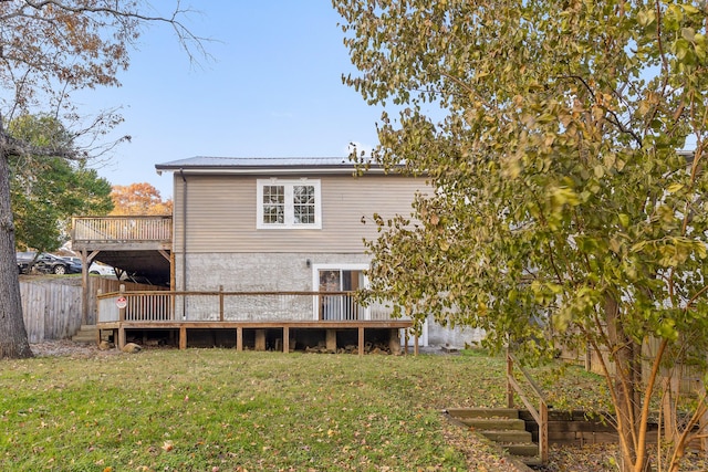 back of property with a yard and a wooden deck