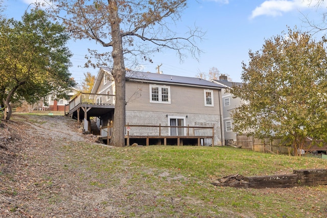 rear view of property featuring a lawn and a deck