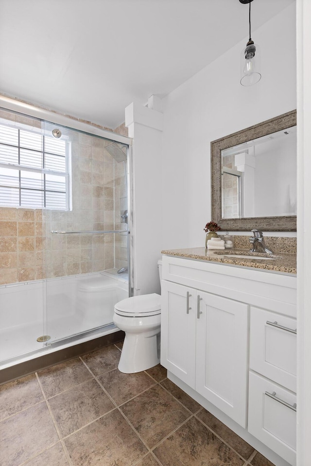 bathroom featuring vanity, toilet, and an enclosed shower