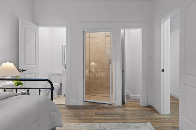 bedroom with ensuite bathroom and dark wood-type flooring