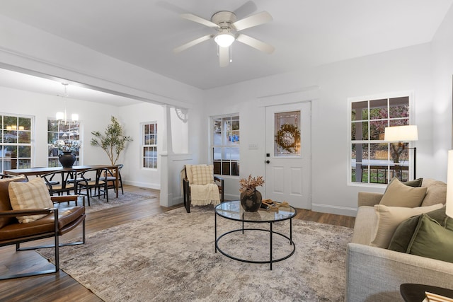 living room with hardwood / wood-style floors and ceiling fan with notable chandelier