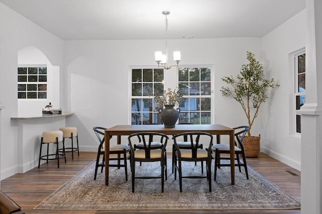 dining area featuring a notable chandelier and dark hardwood / wood-style floors