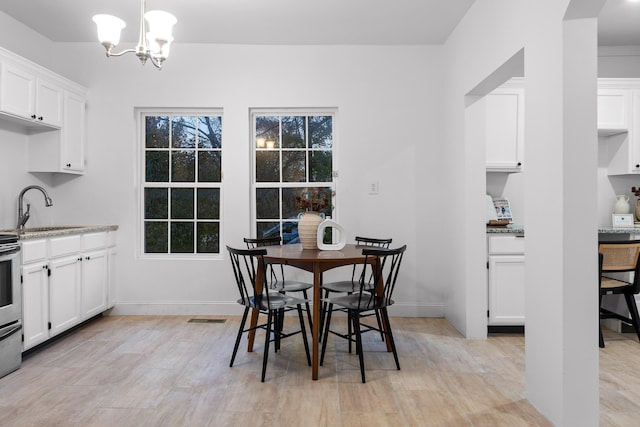 dining room featuring light hardwood / wood-style floors, sink, and a chandelier