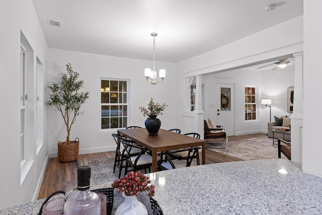 dining area with wood-type flooring and ceiling fan with notable chandelier