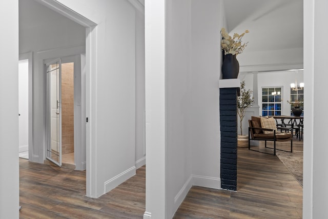 hallway with a chandelier and dark hardwood / wood-style flooring