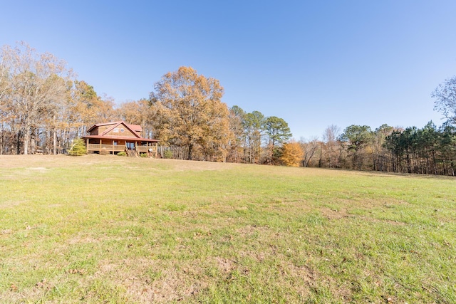 view of yard with a wooded view and a deck