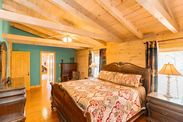 bedroom with multiple windows, vaulted ceiling with beams, wood walls, and wood finished floors